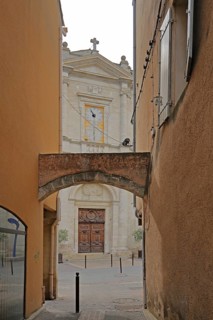 View baroque church Notre-Dames-des-Angers from narrow alley with archway, view through, narrow,
