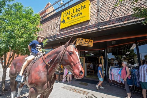 Steamboat Springs, Colorado, A boy sits on a fiberglass horse outside F.M. Light & Sons, a