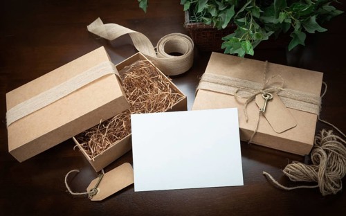 Gift packaging boxes mock up with jute string, blank card and tags with small key on wood surface