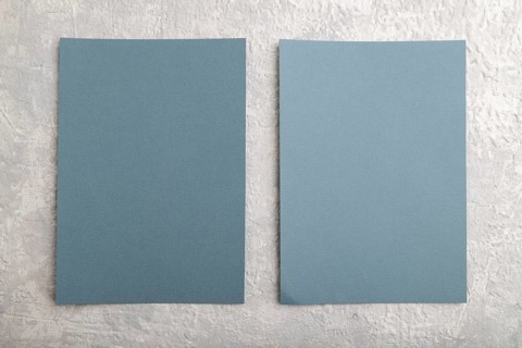 Blue paper business card, mockup on gray concrete background. Blank, flat lay, top view, still