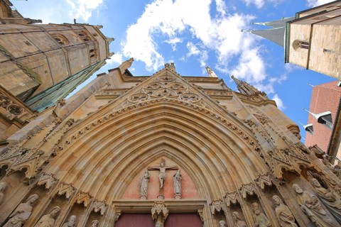 Portal with tympanum with Mary, Jesus on the crucifix and John from the UNESCO cathedral and tower
