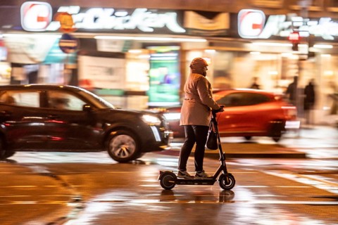 Street at the main station, e-scooter driver, rainy weather, city centre, in the evening, Essen,