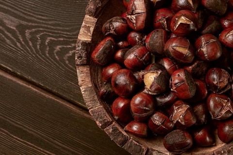 Roasted chestnuts, in a wooden plate, top view, homemade, no people