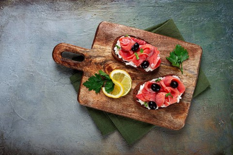 Sandwiches with cream cheese, chum salmon, cold smoked, grain bread, on a cutting board, top view,