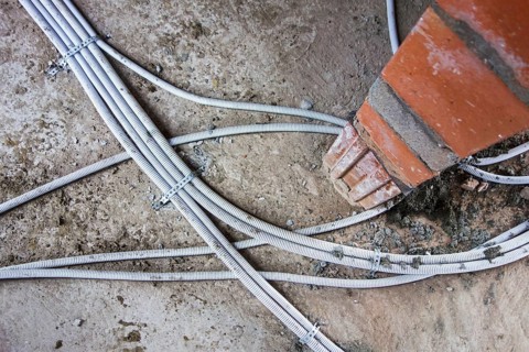 Electric wires, electrical cables, wiring fixed on the floor in newly built house under