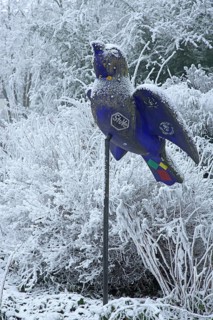 Blue Ulm sparrow with hoarfrost, ice and snow in winter, iced, sculpture, landmark, bird figure,