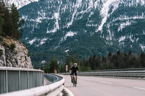 Road bike rider in spring in the Allgäu against the picturesque backdrop of the Alps, Bavaria,