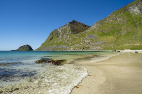 Landscape with sea at the sandy beach of Haukland with the mountain Veggen. Shot during the day