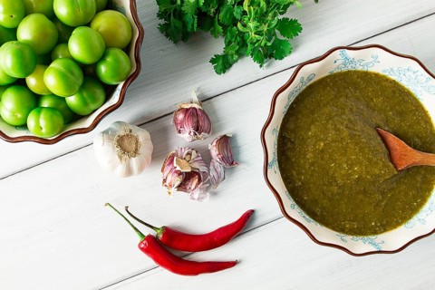Tkemali sauce, traditional Georgian cuisine, green cherry plum, with ingredients for sauce,