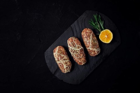 Traditional Cypriot Seftalia dish, raw, top view, on a black background, no people