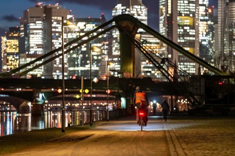 Skyline of the city centre of Frankfurt am Main, cyclist with light on the cycle path, pavement,