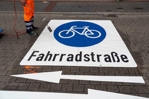 Application of road markings for a cycle lane, Rüttenscheider Straße in Essen, in the shopping and