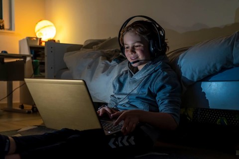 Boy, at home on the computer, laptop, in the children's room, playing a game, chatting with other