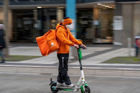 Delivery service Lieferando.de, delivery courier with e-scooter in the city centre, Rathenaustraße,