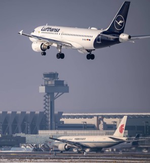 Lufthansa Airbus A319-100 approaching Frankfurt FRA airport, air traffic control tower, Fraport, in