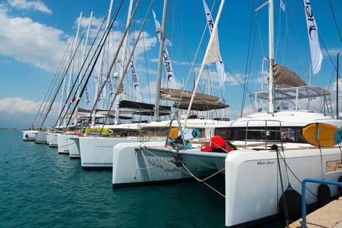Row of catamarans in the harbour with clear blue sky and calm sea, Mediterranean yacht show,