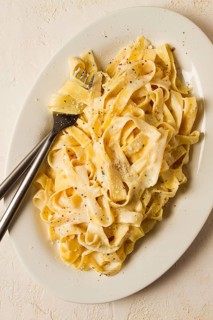 Fettuccine, tagliatelle, in creamy garlic sauce, Italian traditional cuisine, pasta carbonaro