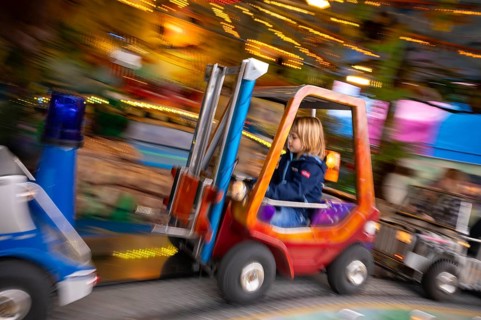 Boy, 5 years, blond, in children's carousel, carousel, movement, wiping effect, carnival, spring