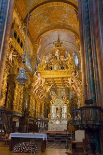 Gold-decorated Baroque church interior with an ornately decorated altar and angels, cathedral,