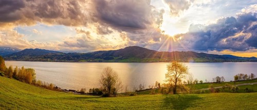 Picturesque landscape with lake, mountains and dramatic sky at sunset, Attersee, Austria, Europe