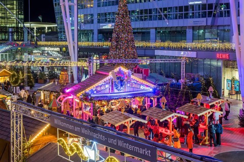 Christmas market at the airport in the evening, market stalls decorated for Christmas in front of