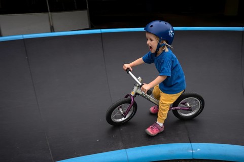 Little girl, 3 years, blonde, helmet, helmet, riding on balance bike, bicycle, skating rink,