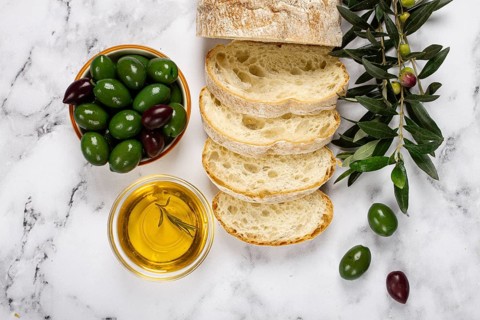 Appetizer, sliced ciabatta bread, with olive oil, green olives, Chalkidiki olives, classic Green