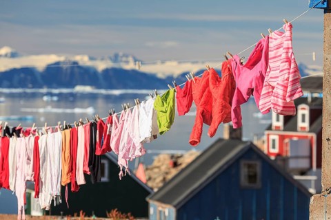 Colourful laundry drying on a washing line in an Inuit settlement, Ittoqqortoormiit, Scoresby Sund,