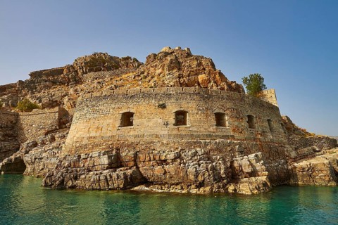 Ancient fortress on rocky coastal terrain with clear blue sea and sky, Venetian sea fortress, Leper