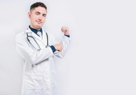 Doctor pointing back with his thumbs, recommending a product. Smiling latin doctor pointing back