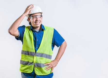 Troubled young engineer holding head isolated. Worried builder engineer holding head isolated.