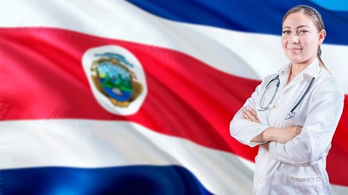 Smiling doctor with crossed arms with Costa Rican flag in the background. Health care concept with