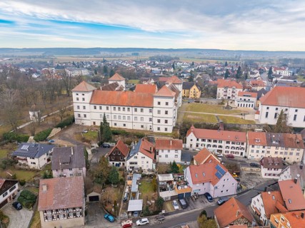 Historic castle surrounded by small houses and rural landscape under a cloudy sky, Meßkirch,