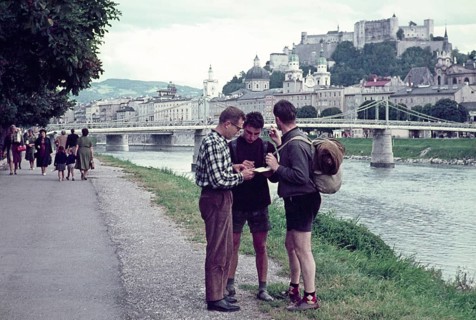 Two hitchhikers being helped with directions by a man, Salzach River riverbank, Salzburg, Austria