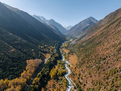 Aerial view, mountain stream Ala Archa flows through the Ala Archa valley, autumnal mountain