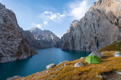Wild camping, camping in the wilderness with a tent in front of mountain lake Kol Suu, Sary Beles