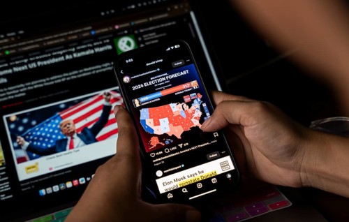 In this photo illustration, a person watch results of U.S. elections on a smartphone in Guwahati,