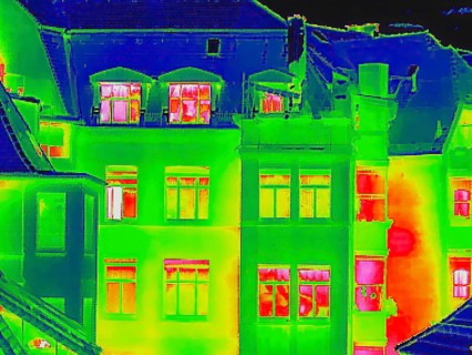 Apartment block, facade of a residential building with windows. Thermal image or thermography,