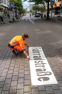 Application of road markings for a cycle lane, Rüttenscheider Straße in Essen, in the shopping and