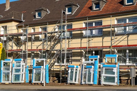 Energy-efficient refurbishment of residential buildings, older apartment block is scaffolded, gets