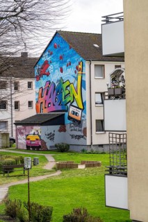 Housing estate, apartment buildings, colourful mural with local reference, music, 99 balloons, in