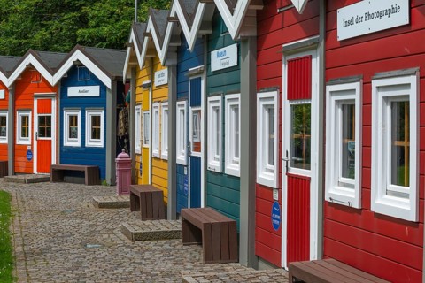 Colourful lobster shacks in the outdoor area of the museum with different themed areas, benches,