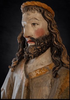 Palmesel, detail of Christ's head, wooden figure from 1470, on a dark background, Franciscan