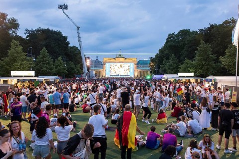 Fassball fans celebrate and gather information in the fan zone at the Brandenburg Tor after the