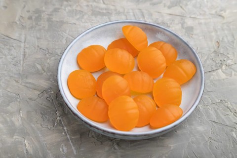 Jelly pumpkin candies on gray concrete background. close up, side view. autumn concept