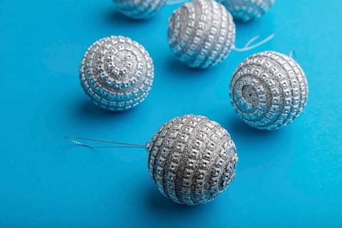 Christmas or New Year composition. Decorations, silver balls, on a blue paper background. Side