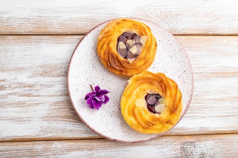 Small cheesecakes with jam and almonds on a white wooden background. top view, flat lay, close up