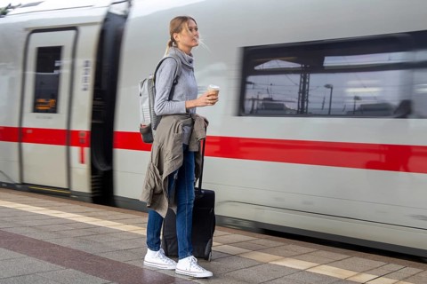 Young woman on the railway track while a train arrives