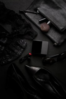 Women's accessories, black heeled shoes, cosmetics, underwear, top view, on a black background,
