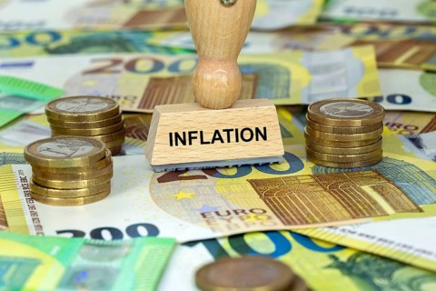 Symbolic image of inflation: stamp with the inscription Inflation on euro banknotes